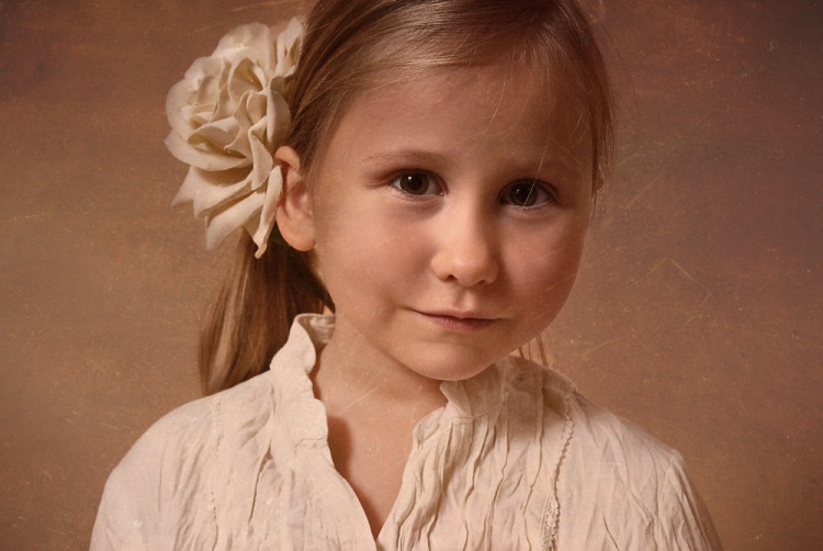 Børneportræt i gammeldags look af lille pige – billedet ser romantisk og slidt ud på en gang