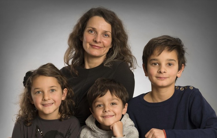 En mor og hendes tre børn på gruppebillede, der er taget tæt på og i farve
