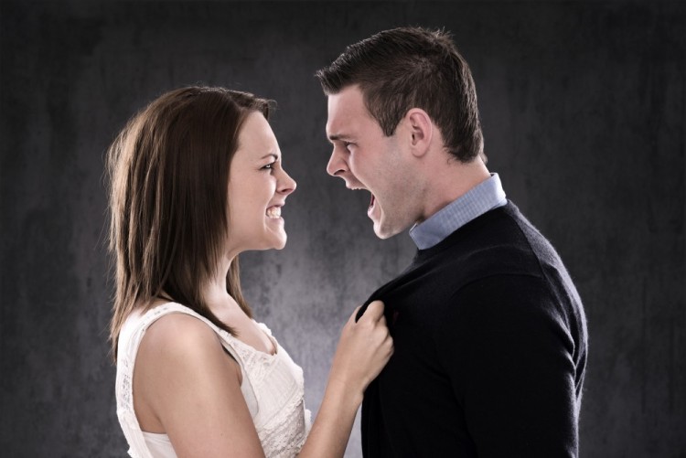 Billede af mand og kvinde, der råber ad hinanden og skændes, hun har fat i hans bluse