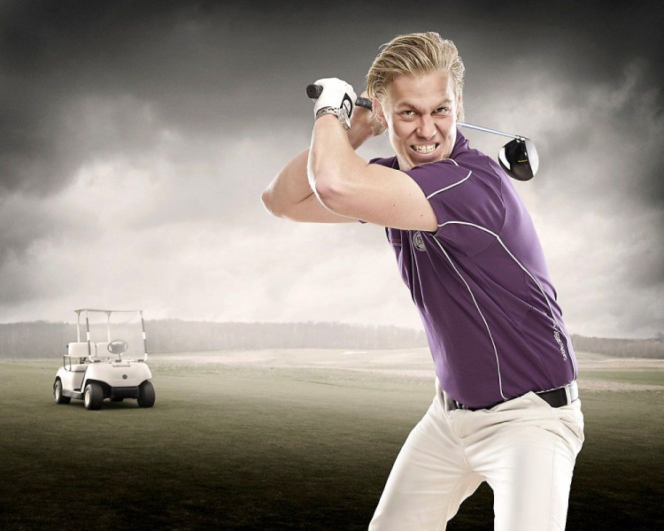 Billede af ung golfspiller, der svinger golfkøllen – golfvogn i baggrunden