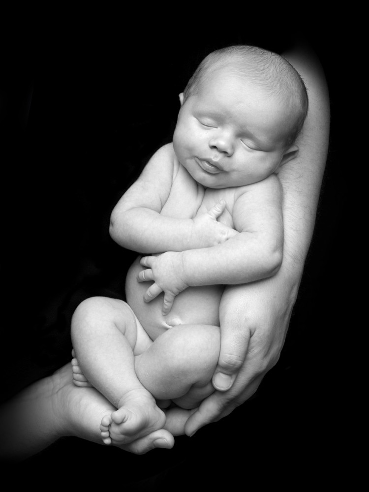 Lille baby på 4 uger får taget sit første månedsfoto i fars trygge arme