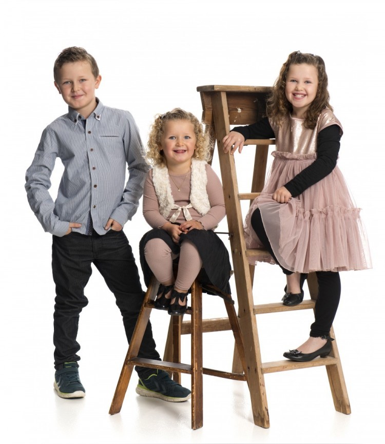 Børneportræt af tre søskende med stiger som rekvisitter