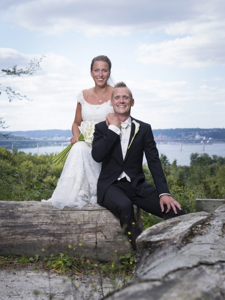 Bryllupsbillede taget i naturen med vand i baggrunden