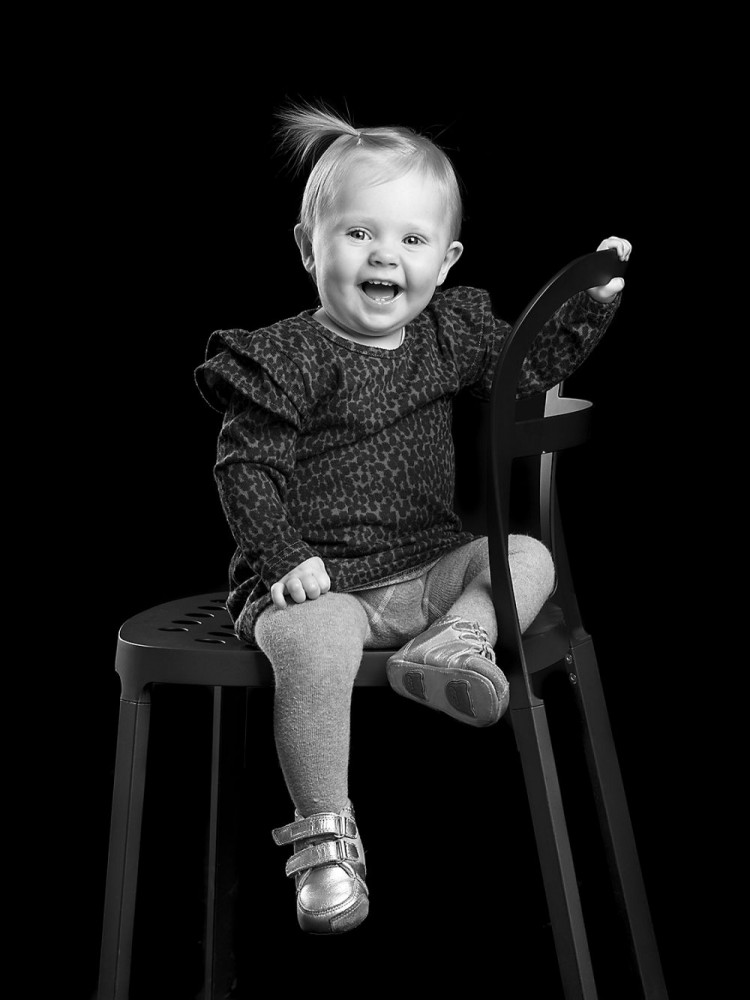 Månedsbillede af pige, der sidder på en stol, fotografiet er i sort-hvid