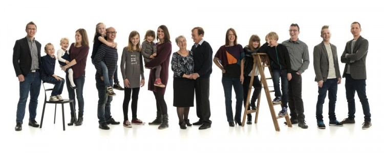 ruppebillede af hele familien – 17 personer i helfigur smiler på billede i bredformat